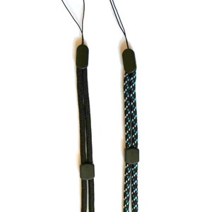 May include: Two black camera straps with adjustable loops. One strap is solid black, the other has a blue and white pattern.