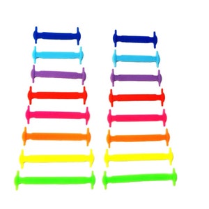 May include: A set of 12 colourful elastic shoelace replacements. The shoelaces are arranged in two rows of six, with each row featuring a different colour. The colours include blue, light blue, purple, red, pink, orange, yellow, and green.