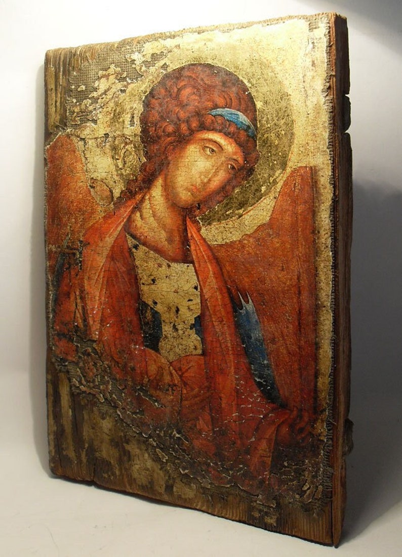 May include: An antique icon painting of an angel with red and blue clothing. The icon is painted on a wooden panel and has a distressed, aged appearance.