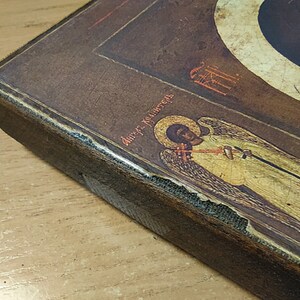 Puede incluir: Un icono enmarcado en madera con una imagen pintada de un &aacute;ngel con alas. El &aacute;ngel sostiene un bast&oacute;n y tiene un halo. El icono est&aacute; en un marco marr&oacute;n oscuro con una inscripci&oacute;n dorada que dice "&Aacute;ngel del Se&ntilde;or".