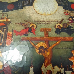 May include: An antique religious icon depicting the crucifixion of Jesus Christ. The artwork features a central cross with a figure, angels, and architectural elements. The color palette includes reds, blues, and golds, with visible text in the upper portion.