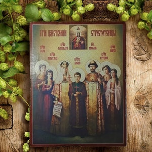 May include: A religious icon depicting a group of people in traditional clothing. The icon is painted on a wooden panel and features the text "Святи Царственни" and "Страстотерпцы".