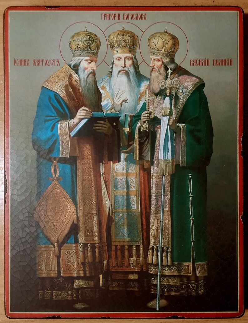Puede incluir: Un icono que representa a tres hombres con t&uacute;nicas y coronas adornadas. El icono est&aacute; pintado en un panel de madera y presenta el texto "ГРИГОРИЙ БОГОСЛОВ", "КОНСТАНТИН АВТОГУСТ" y "ВАСИЛИЙ ВЕЛИКИЙ".