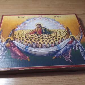 May include: A religious icon depicting Jesus Christ surrounded by angels and a multitude of people. The icon is painted on a wooden panel with a red and gold frame. The text "Ta Ala" and "Ninima" is visible at the top of the icon.