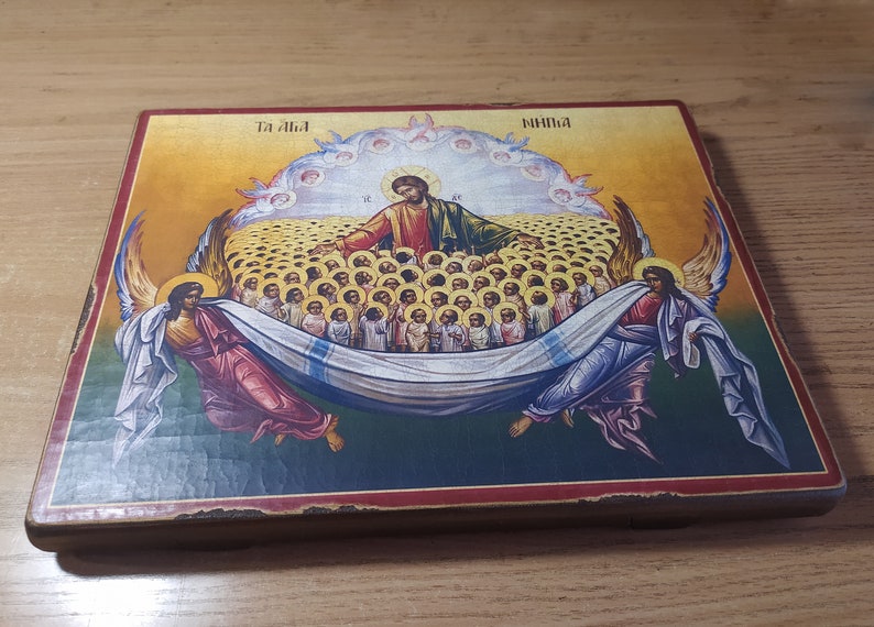 May include: A religious icon depicting Jesus Christ surrounded by angels and a multitude of people. The icon is painted on a wooden panel with a red and gold frame. The text "Ta Ala" and "Ninima" is visible at the top of the icon.