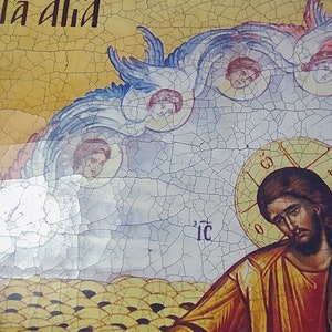 May include: A vintage religious icon painting depicting Jesus Christ with a halo and a yellow robe. The painting is on a cracked, yellow background with blue and white clouds and angels. The text "T&aacute; &aacute;lla" is written in black at the top of the painting.