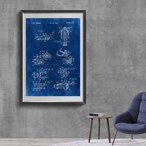 May include: A blue and white vintage patent drawing for a toy robot. The drawing shows the robot in different positions, including standing, sitting, and transforming into a vehicle. The patent number is 4,183,173.