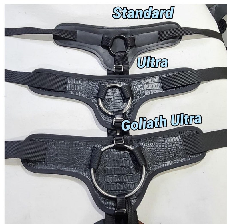 May include: Three black leather harnesses with metal rings, labeled "Standard", "Ultra", and "Goliath Ultra".