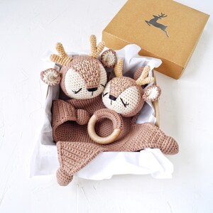 Peut inclure: Un coffret cadeau pour b&eacute;b&eacute; comprenant deux jouets en forme de cerf au crochet, un anneau de dentition en bois et une couverture, dans des tons marron et cr&egrave;me. Le tout est pr&eacute;sent&eacute; dans une bo&icirc;te en carton.