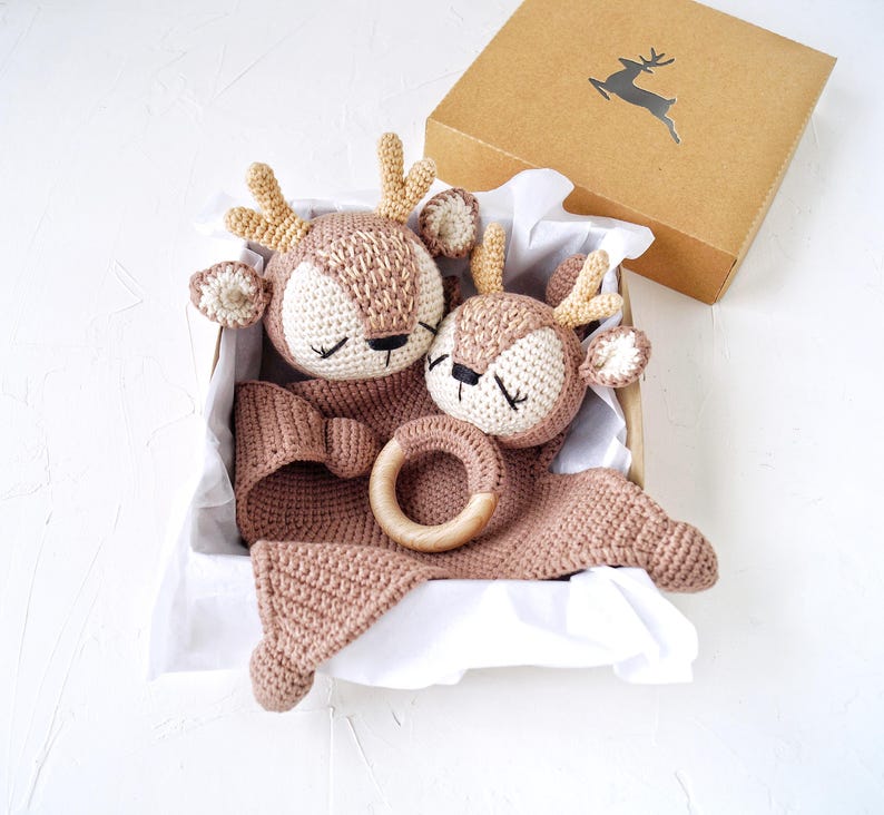Peut inclure: Un coffret cadeau pour b&eacute;b&eacute; comprenant deux jouets en forme de cerf au crochet, un anneau de dentition en bois et une couverture, dans des tons marron et cr&egrave;me. Le tout est pr&eacute;sent&eacute; dans une bo&icirc;te en carton.