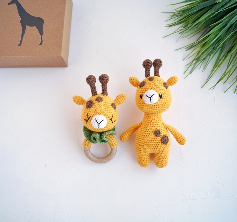 May include: Two crocheted giraffe toys. One is a rattle with a wooden ring and the other is a larger stuffed toy.