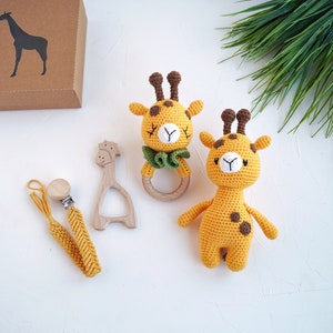 May include: Two crocheted giraffe toys, one with a wooden teething ring, and a yellow crocheted pacifier clip with a wooden clip.