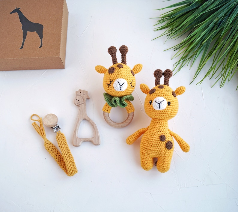 May include: Two crocheted giraffe toys, one with a wooden teething ring, and a yellow crocheted pacifier clip with a wooden clip.