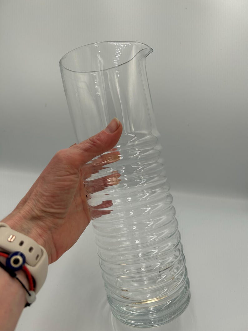 May include: A set of three ceramic mugs with a speckled, matte finish. The mugs are in shades of cream, light gray, and dark gray. Each mug has a simple, minimalist design and a rounded handle. The mugs are stacked on top of each other.