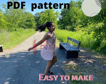 Puede incluir: Una niña con un vestido de mameluco rosa camina por un sendero en un parque. El texto "PDF pattern" y "Easy to make romper dress for girls" está en la imagen.