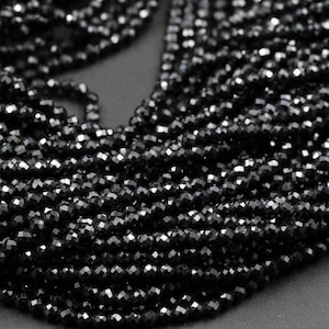 Puede incluir: Una hebra de cuentas de piedras preciosas facetadas negras. Las cuentas son pequeñas y redondas, y tienen un acabado brillante y pulido.