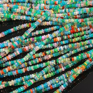 Puede incluir: Una hebra de cuentas de ópalo multicolores. Las cuentas son pequeñas y redondas, y están enhebradas en un hilo transparente. Las cuentas son una mezcla de azul, verde, rosa, naranja y blanco.