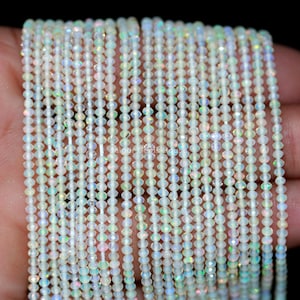 Puede incluir: Una hebra de cuentas de ópalo blanco con forma de lágrima facetada. Las cuentas están enhebradas en un hilo transparente y tienen aproximadamente 3 mm de diámetro.