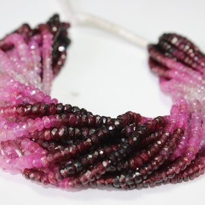 Puede incluir: Una hebra de cuentas de piedras preciosas facetadas en tonos de rosa y rojo. Las cuentas están dispuestas en degradado, con las cuentas de color rosa más claro en un extremo y las cuentas de color rojo más oscuro en el otro extremo.