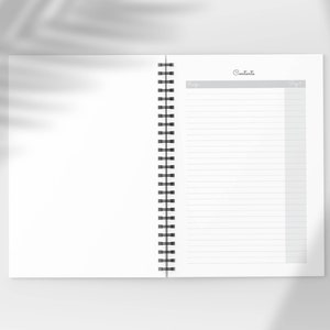 Pu&ograve; includere: Quaderno aperto a spirale, con pagine a righe e una sezione "Sommario". Il quaderno &egrave; bianco con spirale nera. Lo sfondo &egrave; di un tono morbido e neutro con un'ombra di foglia.