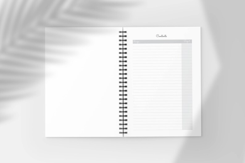Pu&ograve; includere: Quaderno aperto a spirale, con pagine a righe e una sezione "Sommario". Il quaderno &egrave; bianco con spirale nera. Lo sfondo &egrave; di un tono morbido e neutro con un'ombra di foglia.