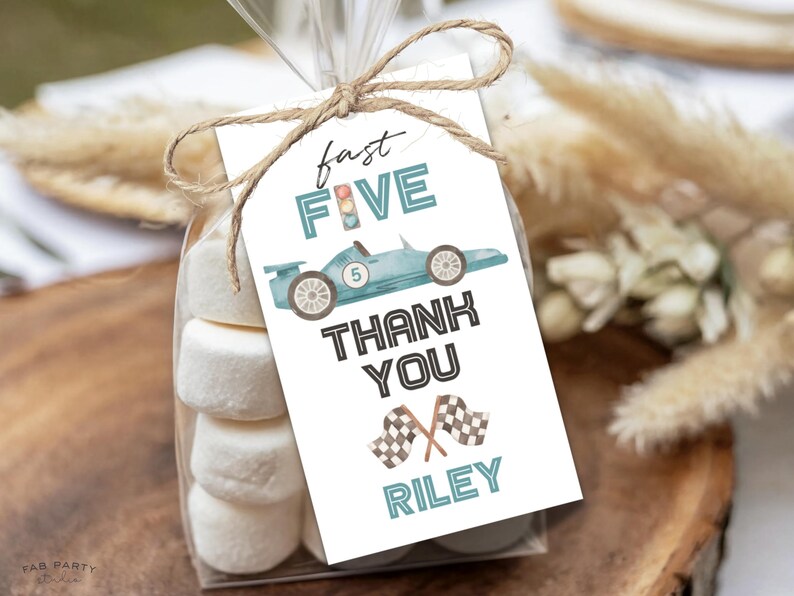 May include: A cellophane bag filled with marshmallows, tied with twine and a tag. The tag has a light blue race car graphic and the words "fast FIVE THANK YOU RILEY" in black and teal lettering.