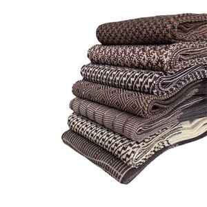 Peut inclure: Six paires de chaussettes à motifs marrons et beiges empilées les unes sur les autres. Les chaussettes sont pliées et empilées.