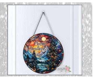 May include: A round stained glass ornament with a winter scene. The ornament features a mountain range, a lake, and a pine tree with lights. The text "Merry Christmas" is written in black lettering on the ornament.