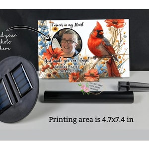 May include: A solar-powered garden stake with a personalised photo area and a cardinal bird design. The stake features the text "Forever in my Heart" and "God made you our Angel". The printing area is 4.7x7.4 inches.