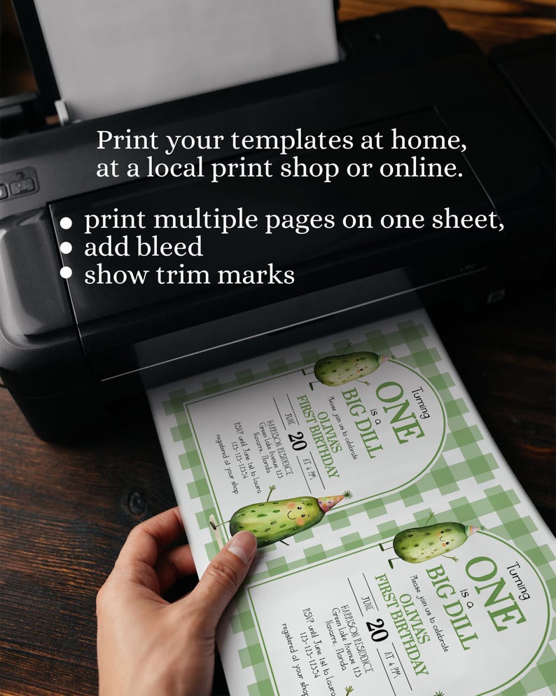 Op de afbeelding: Een zwarte printer die uitnodigingen afdrukt. De uitnodigingen hebben een groen-wit ruitpatroon en een cartoon augurk ontwerp met de tekst "Turning ONE is a BIG DILL". De tekst op de uitnodiging luidt "OLIVIA'S FIRST BIRTHDAY".