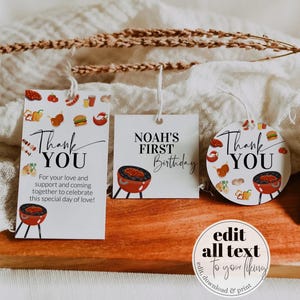 May include: Three white gift tags with string, featuring barbecue-themed illustrations and text. One tag says "Thank You" with a message, another says "Noah's First Birthday", and the third says "Thank You". A round sticker with text is also visible.