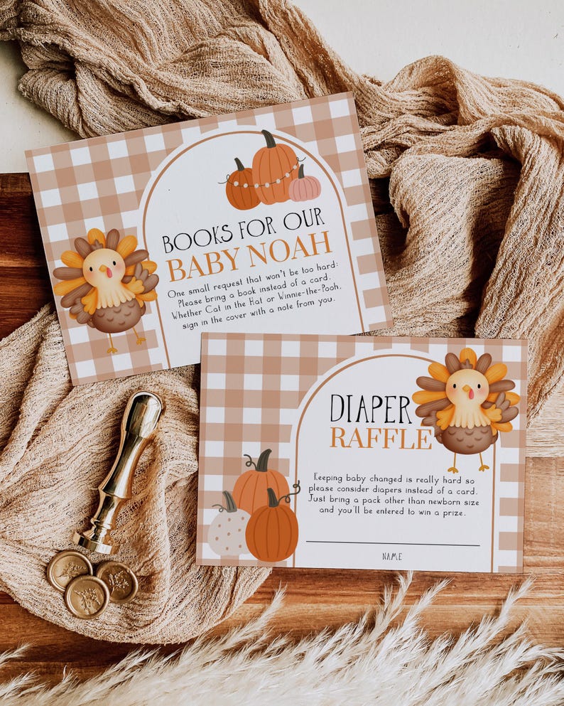 May include: Two baby shower invitation cards with a fall theme. One card reads "Books for our Baby Noah" and the other says "Diaper Raffle". Both cards feature illustrations of pumpkins and a turkey. A gold wax stamp and coins are also visible.