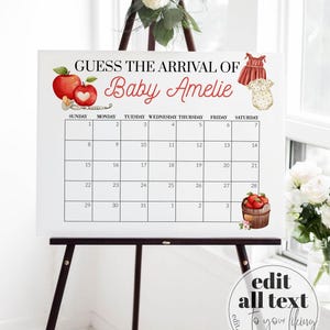 May include: A white sign on a black easel with the text "GUESS THE ARRIVAL OF Baby Amelie" and a calendar grid. The sign is decorated with apple and baby clothes illustrations. The bottom right corner has a circular logo with the text "edit all text to your liking".
