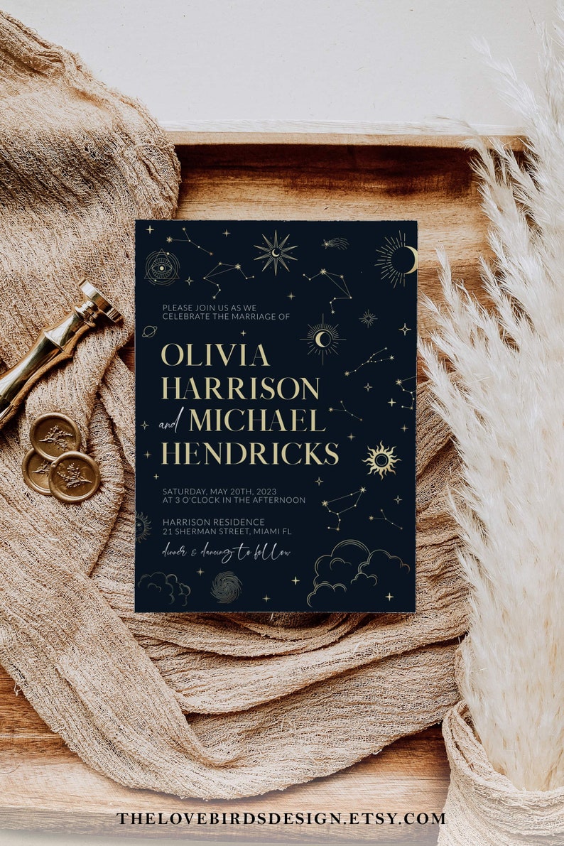 May include: A navy blue wedding invitation with gold foil accents. The invitation features a celestial design with stars, moons, and planets. The text reads "Please join us as we celebrate the marriage of Olivia Harrison and Michael Hendricks. Saturday, May 20th, 2023 at 3 o'clock in the afternoon. Harrison Residence, 21 Sherman Street, Miami FL. Dinner & dancing to follow."
