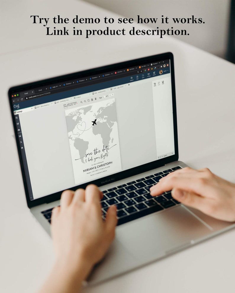 May include: A laptop screen showing a wedding invitation design with a world map and an aeroplane graphic. The text on the screen reads "save the date & book your flights" and "MIRIAM & CHRISTOPH". The laptop is open, and the user is typing on the keyboard.