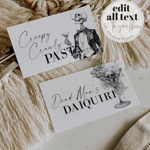 May include: Two rectangular white cards featuring black text and illustrations. One card reads Creepy Crawly PASTA with a skeleton in a tuxedo holding a martini glass. The other card reads Dead Man's DAIQUIRI with a skull inside a spiderwebbed glass.