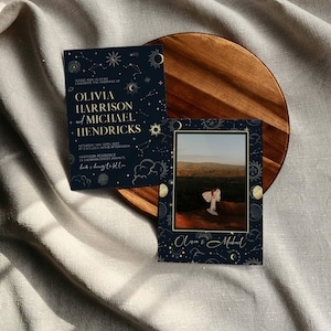 May include: A dark blue wedding invitation with gold foil accents. The invitation features a celestial design with stars, moons, and planets. The text reads "Please join us as we celebrate the marriage of Olivia Harrison and Michael Hendricks. Saturday, May 20th 2023 at 3 o'clock in the afternoon. Harrison Residence 21 Sherman Street, Miami FL."