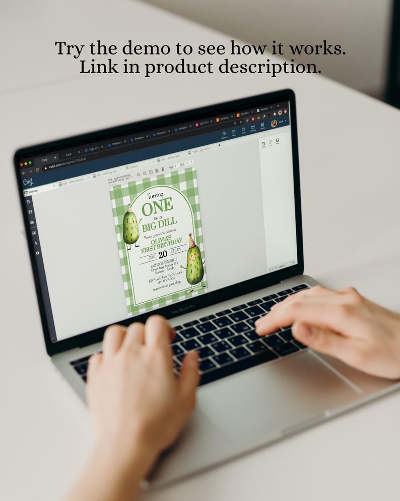 Op de afbeelding: Een laptop toont een verjaardagsuitnodiging met een groen en wit ruitpatroon. De uitnodiging luidt "Turning ONE Big Dill" met een cartoon augurk illustratie. De tekst "Try the demo to see how it works. Link in product description." staat bovenaan.