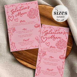 May include: Two pink printable Galentine's Day menu cards with red text and illustrations. The menu includes a starter, main course, and dessert. The text on the cards reads "Galentine's Menu" and includes the sizes 5x7 and 4x8.