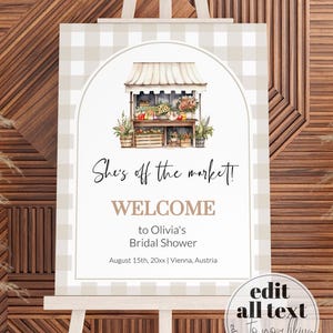 May include: A welcome sign for a bridal shower with a watercolor illustration of a market stall with flowers and produce. The text reads "She's off the market! Welcome to Olivia's Bridal Shower August 15th, 20xx | Vienna, Austria".