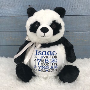 Może przedstawiać: Pluszowa panda z czarno-białym futerkiem i jasnoszarą wstążką wok&oacute;ł szyi. Na białym brzuszku wyhaftowano imię Isaac, drugie imię Victor, wagę 7 pounds 5 ounces, wzrost 20 inches, godzinę 7:43 AM oraz datę 22-06-2021.