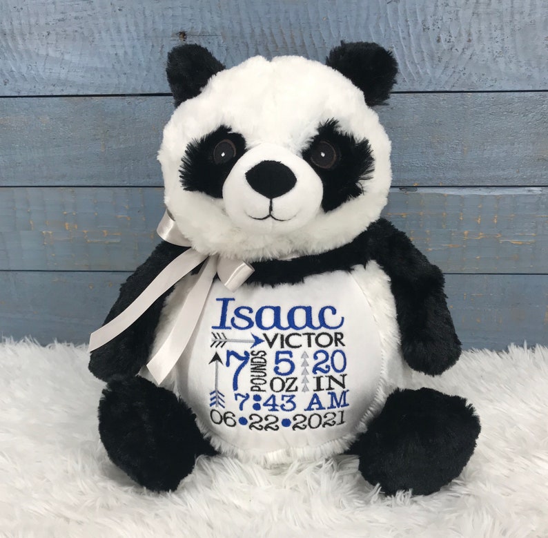 Może przedstawiać: Pluszowa panda z czarno-białym futerkiem i jasnoszarą wstążką wok&oacute;ł szyi. Na białym brzuszku wyhaftowano imię Isaac, drugie imię Victor, wagę 7 pounds 5 ounces, wzrost 20 inches, godzinę 7:43 AM oraz datę 22-06-2021.