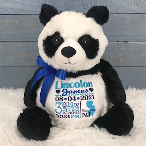 Może przedstawiać: Pluszowa panda z czarno-białym futerkiem, przewiązana niebieską satynową wstążką na szyi. Na białym brzuszku znajduje się niebieski haft z tekstem: Lincolon James, 08-04-2021, 3 pounds 14 oz, 17.5 inches, 3:03 PM oraz Voorhees NJ.