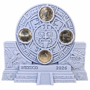 May include: A light gray, circular Aztec calendar sculpture featuring a central face with a protruding tongue. Four gold-colored coins are embedded in the circular frame. The base displays the text MEXICO and 2026, flanked by relief carvings of birds.