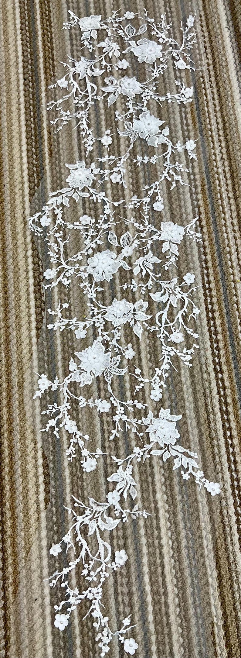 May include: White lace trim with floral designs. The lace features delicate flowers and leaves, perfect for adding a touch of elegance to any project.