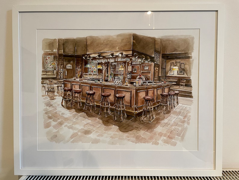Puede incluir: Pintura a la acuarela de una escena de bar, enmarcada en blanco. La barra es marr&oacute;n con una fila de taburetes. El suelo est&aacute; embaldosado. La barra tiene vasos colgados encima. La pintura tiene un ambiente c&aacute;lido y acogedor.
