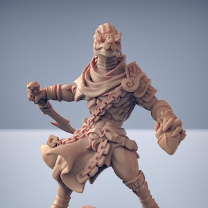 May include: A miniature figurine of a lizard person warrior, painted in a light brown color. The figure is wearing a chainmail shirt, a hooded cloak, and a leather skirt. The figure is holding a dagger in one hand and a shield in the other.