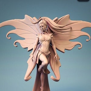 Op de afbeelding: Drie verschillende versies van een 3D-geprint beeldje van een fee met vlinder vleugels. De fee staat op een voetstuk en heeft lang, golvend haar. De vleugels zijn gedetailleerd en ingewikkeld.