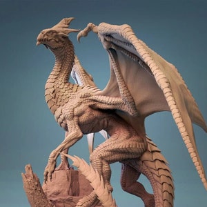 Puede incluir: Un modelo esculpido detallado de un dragón con las alas extendidas, de pie sobre una base rocosa. El dragón está hecho de un material marrón claro y tiene una superficie texturizada.