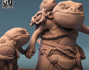 Op de afbeelding: Een 3D-geprint miniatuur van een kikkerachtig wezen met een kleinere kikker op zijn rug. De grotere kikker draagt een touwgordel en heeft een schelp op zijn rug. De kleinere kikker houdt een kleine bol vast. Het miniatuur is in lichtgrijs geverfd. De tekst "THE SHELLBACK RITUAL" is onder het miniatuur gedrukt.